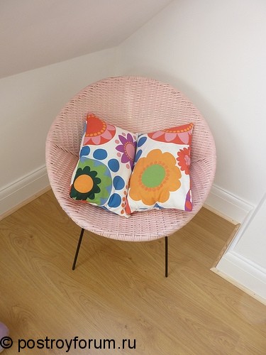 Плетеное кресло с цветастой подушкой