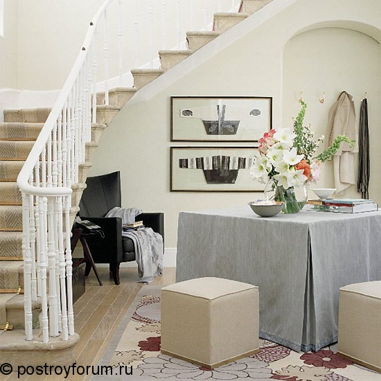 Посередине удобно устроился стол и пуфики для прихожей (фото), под лестнице
