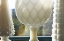Белые гравированные вазы на подоконике