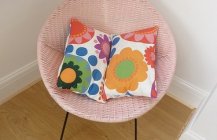 Плетеное кресло с цветастой подушкой