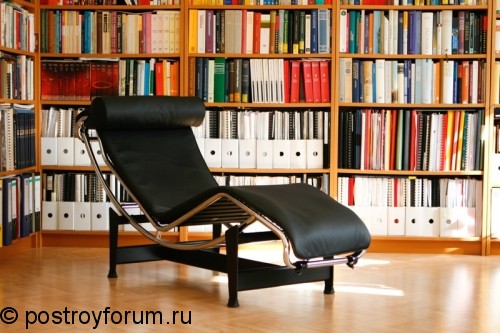Большой книжный шкаф и черное кресло
