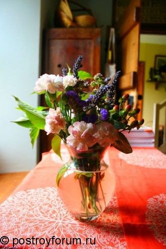 Стол украшеный белым узором и вазой с цветами