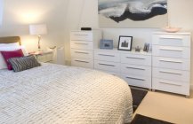 Дизайн белой спальной комнаты с комодом